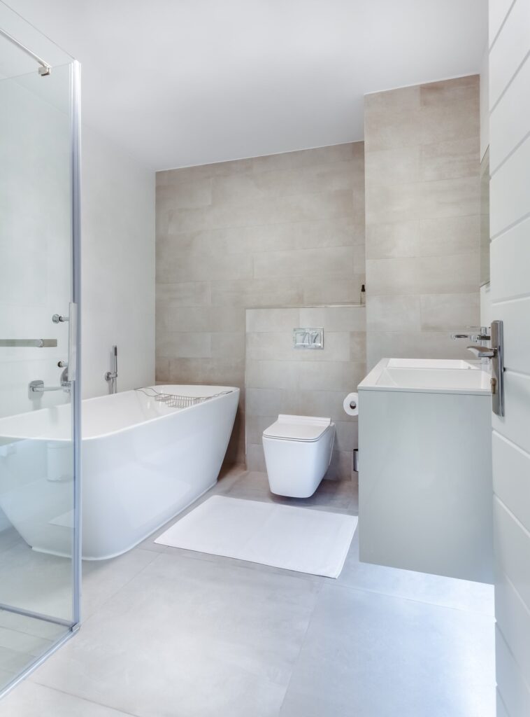 Modern bathroom with bathtub, glass shower, and floating vanity for interior design in Ibiza